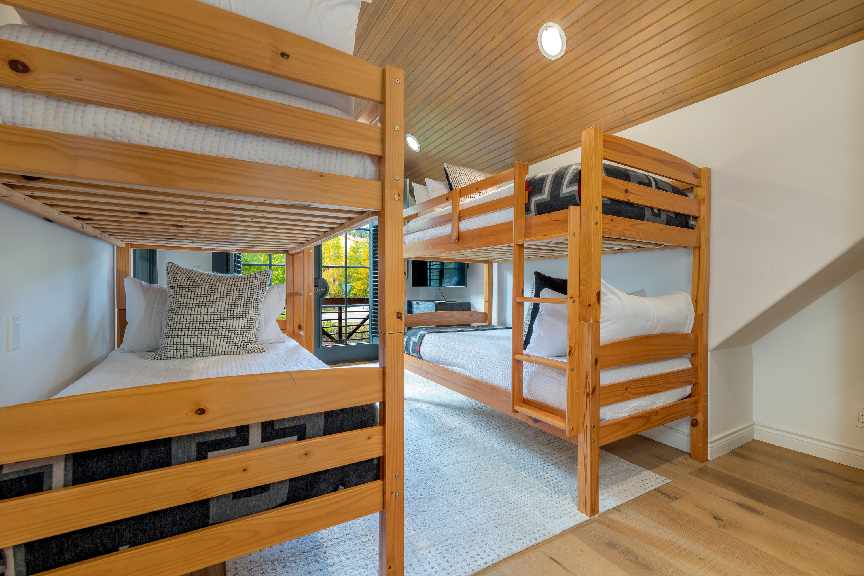 101 Sunny Ridge Place, Unit 101 Mountain Village, CO 81435 - Photo 25 of 30 a bedroom with a bunk bed and a wooden floor