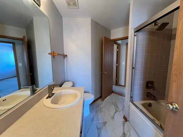 a bathroom with a tub sink and mirror