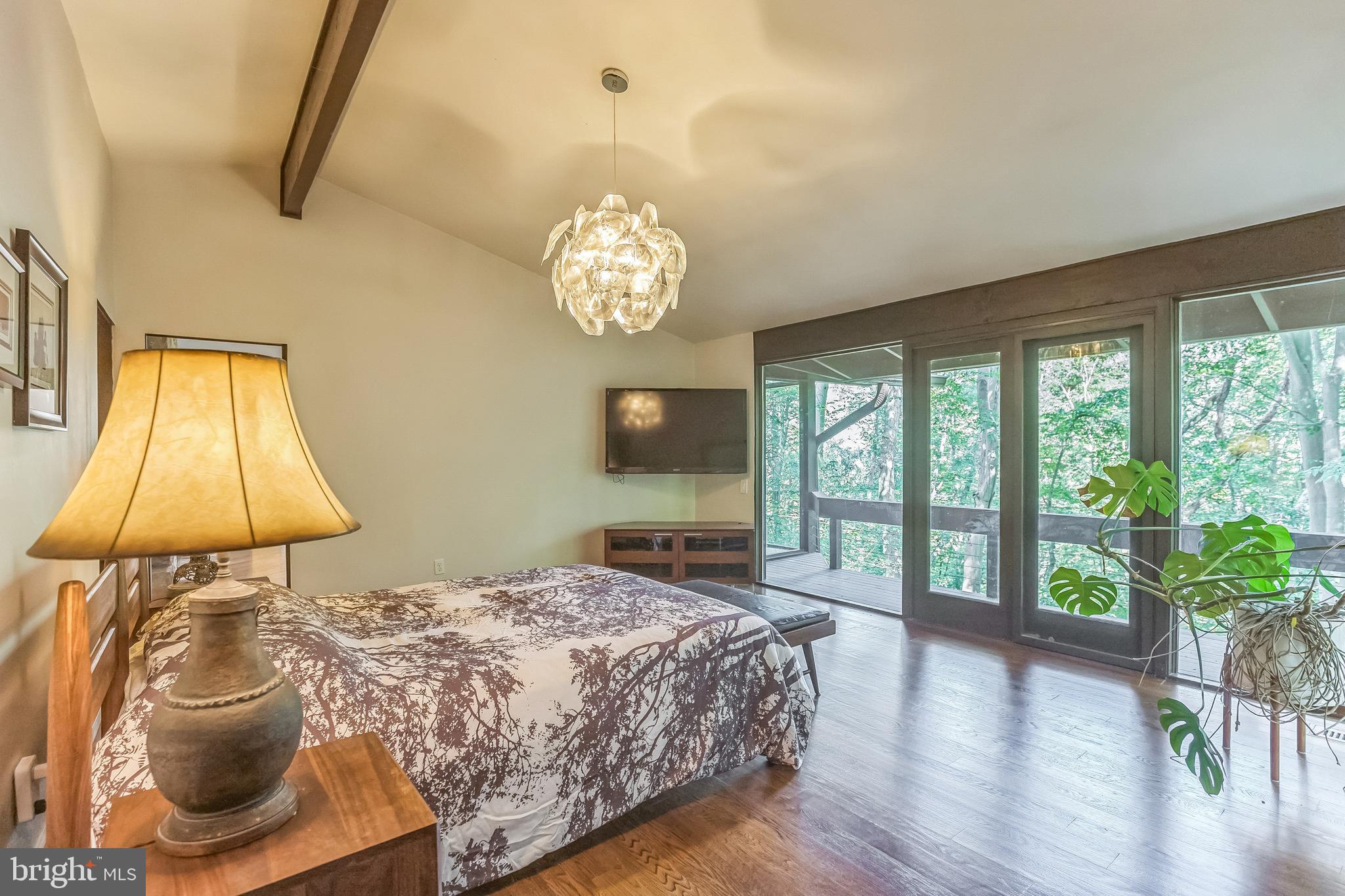 27 Forest View Road Rose Valley, PA 19086 - Photo 34 of 39 a bedroom with a bed and a chandelier