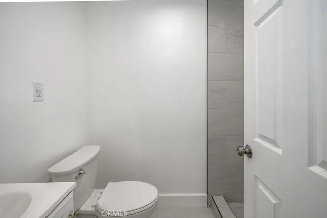 a white toilet sitting next to a shower
