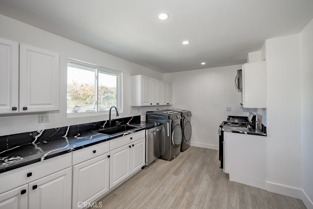 1069 Erringer Road Simi Valley, CA 93065 - Photo 5 of 24 a kitchen with stainless steel appliances a sink a stove a counter space and cabinets