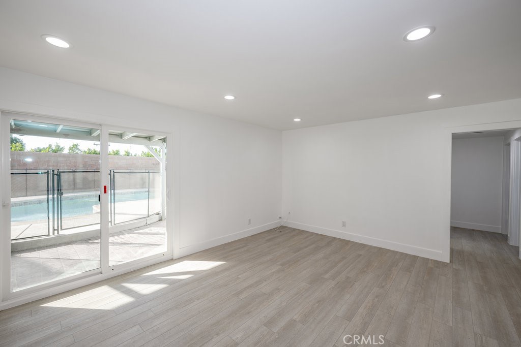1069 Erringer Road Simi Valley, CA 93065 - Photo 8 of 24 an empty room with wooden floor and windows