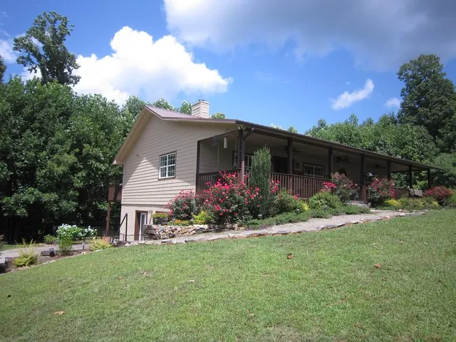 a front view of a house with a yard and potted plants