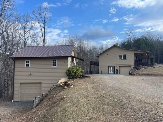 a front view of house with yard and trees in the background