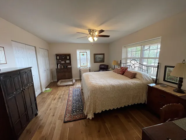 a bedroom with a bed and a large window