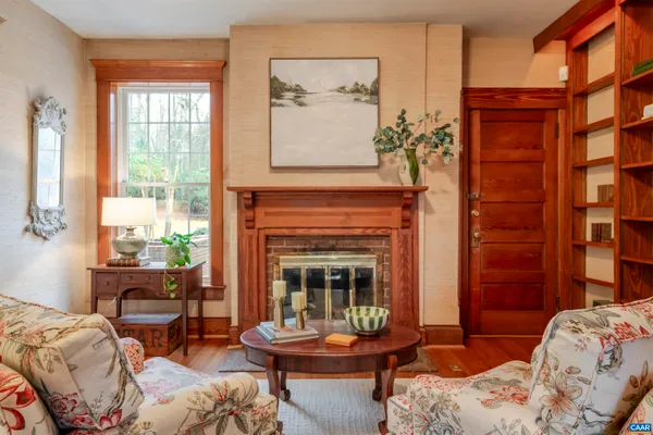 a living room with furniture a fireplace and a floor to ceiling window