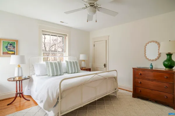 a bedroom with a bed a chair and next to a window