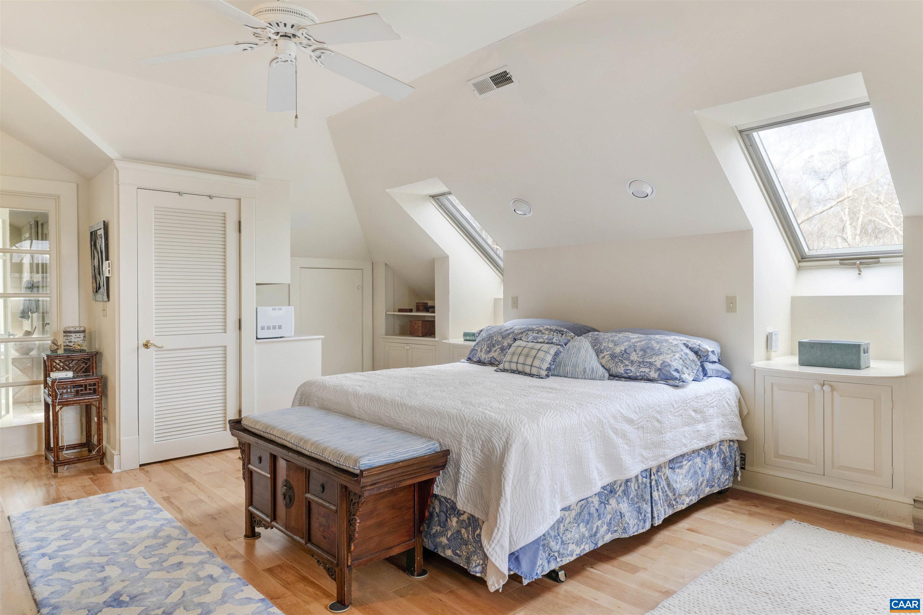 4035 Edge Valley Road North Garden, VA 22959 - Photo 44 of 57 a bedroom with a bed and a table in it with wooden floor