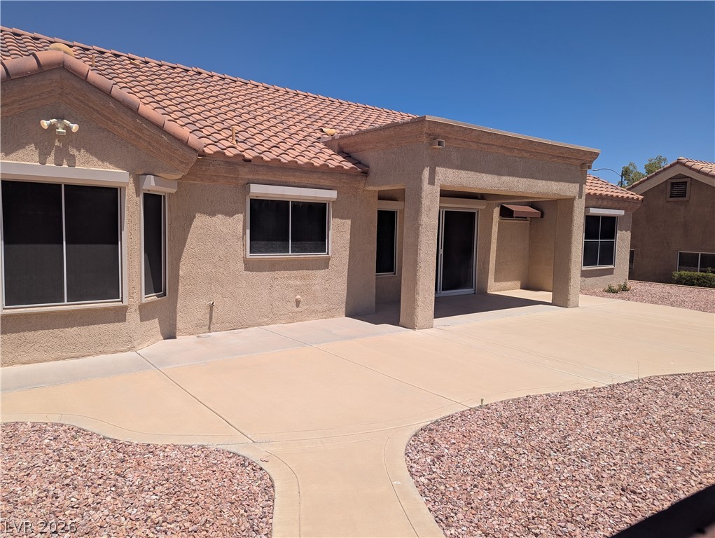 9433 Quail Ridge Drive Las Vegas, NV 89134 - Photo 20 of 23 A spacious outdoor patio and covered area extend from this stucco home with a classic tile roof.