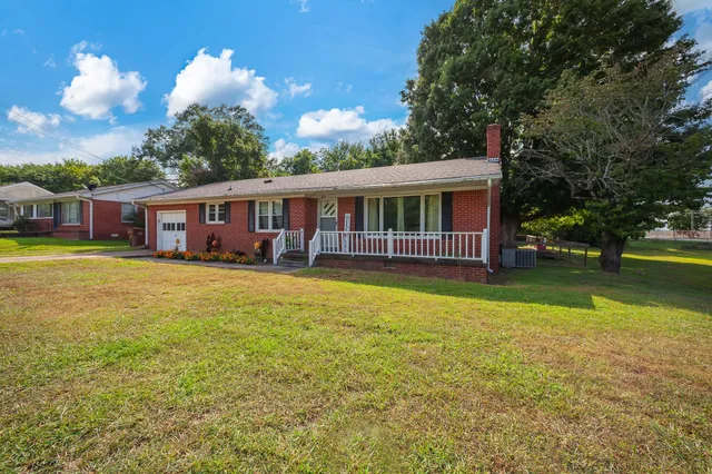 a view of a house with swimming pool next to a yard