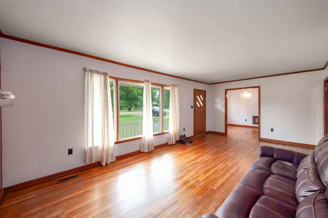 a view of a livingroom with wooden floor and windows