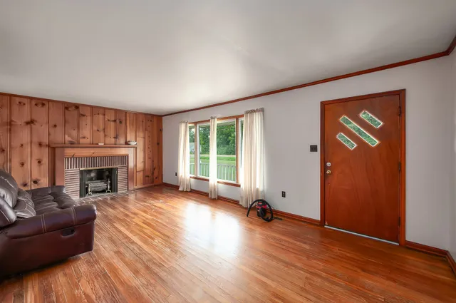 a view of a livingroom with wooden floor and a fireplace