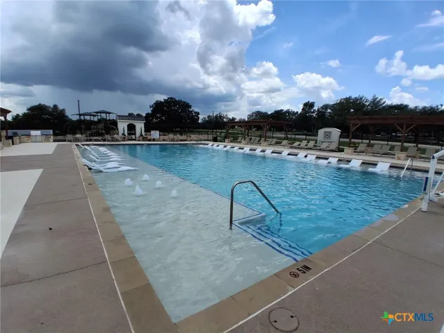 a view of a patio with swimming pool and outdoor seating