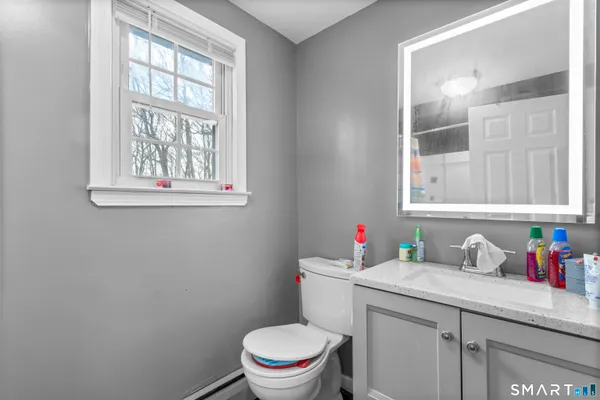 a bathroom with a sink a toilet and a window