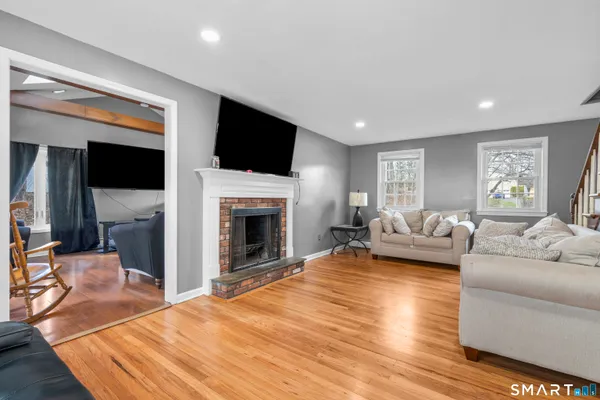a living room with furniture a flat screen tv and a fireplace