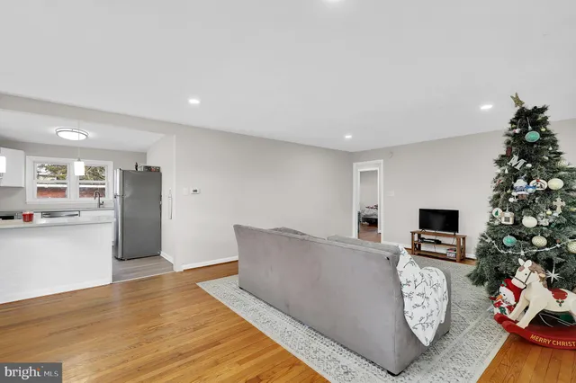 a kitchen with stainless steel appliances a dining table chairs refrigerator and sink