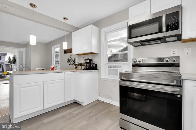 a kitchen with cabinets stainless steel appliances and a window
