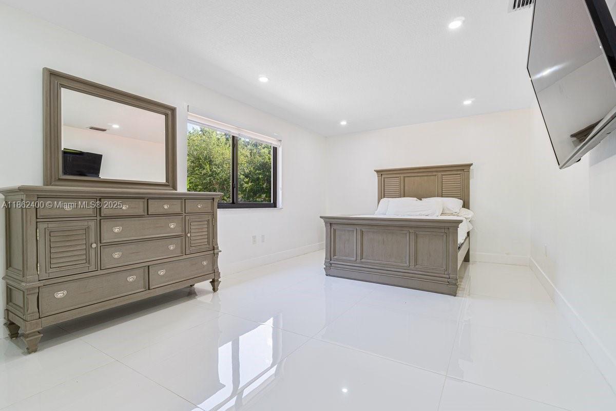 9035 Southwest 156th Court Miami, FL 33196 - Photo 15 of 33 a room with a bed and a mirror on dresser