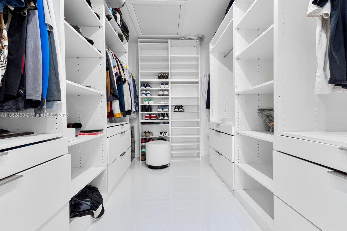 9035 Southwest 156th Court Miami, FL 33196 - Photo 19 of 33 a view of walk in closet with clothes and shoes