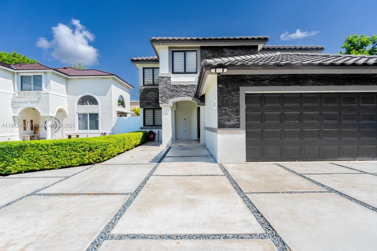 9035 Southwest 156th Court Miami, FL 33196 - Photo 2 of 33 a front view of a house with a garden and plants