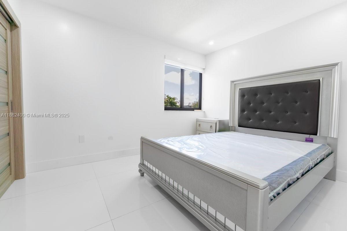 9035 Southwest 156th Court Miami, FL 33196 - Photo 24 of 33 a bedroom with a bed and a flat screen tv