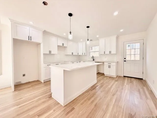 a kitchen with stainless steel appliances kitchen island hardwood floor sink and stove