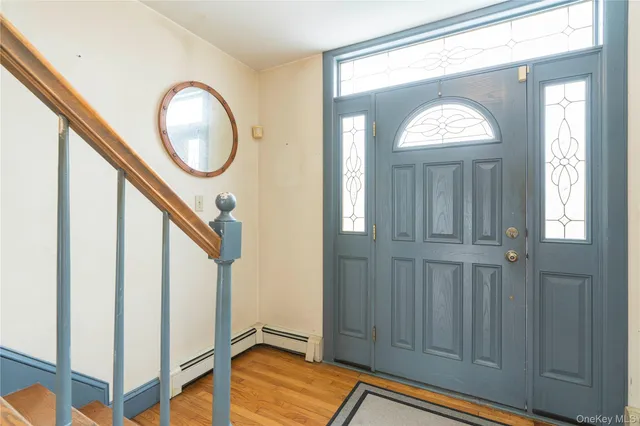 an entryway with wooden floor cabinet and a rug