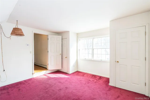 an empty room with windows and cabinet