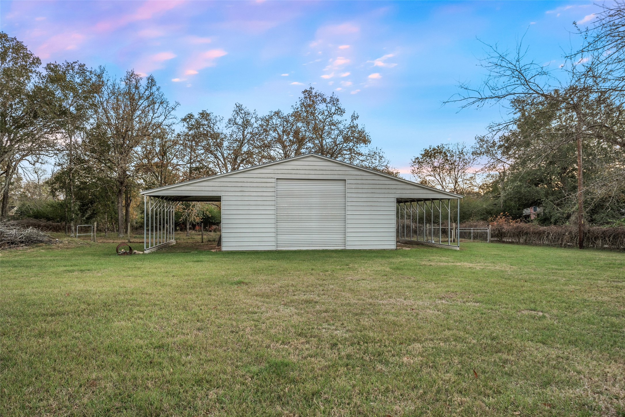 118 Pin Oak Lane Hempstead, TX 77445 - Photo 31 of 33 Detached barn with roll-up door and open bays, suitable for equipment storage, workshop use, or hobby space.