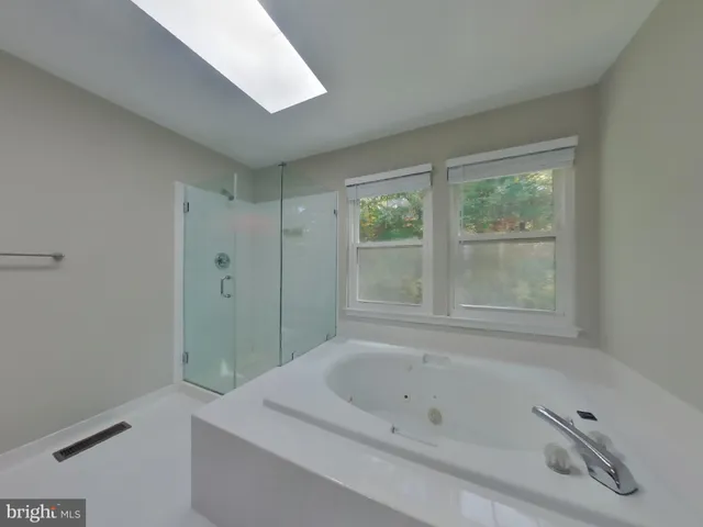 a bathroom with a tub a sink and a shower