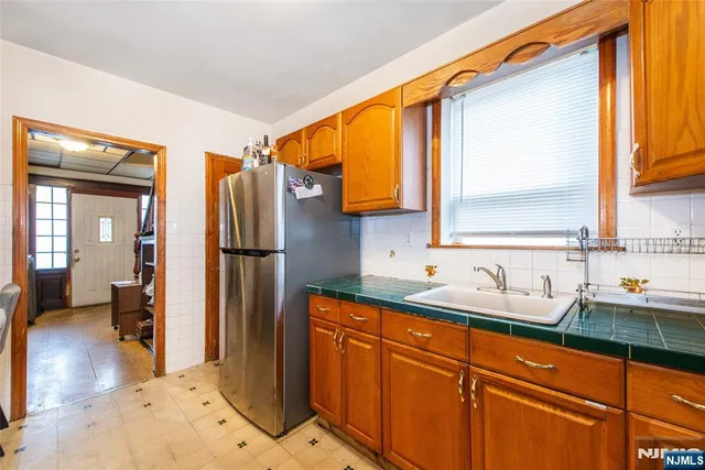 a kitchen with stainless steel appliances granite countertop a sink and a refrigerator