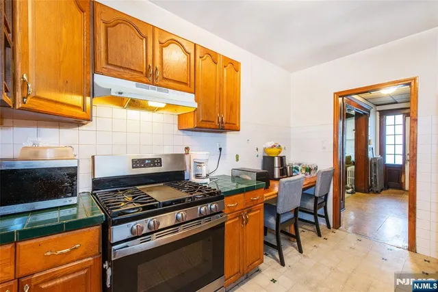 a kitchen with stainless steel appliances granite countertop a stove a sink and a microwave