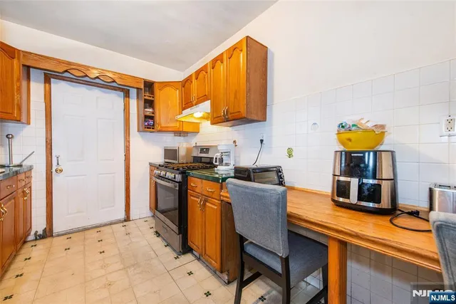 a kitchen with stainless steel appliances granite countertop a sink and a refrigerator