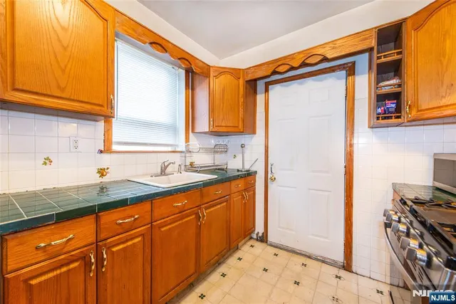 a kitchen with stainless steel appliances granite countertop a sink and a refrigerator