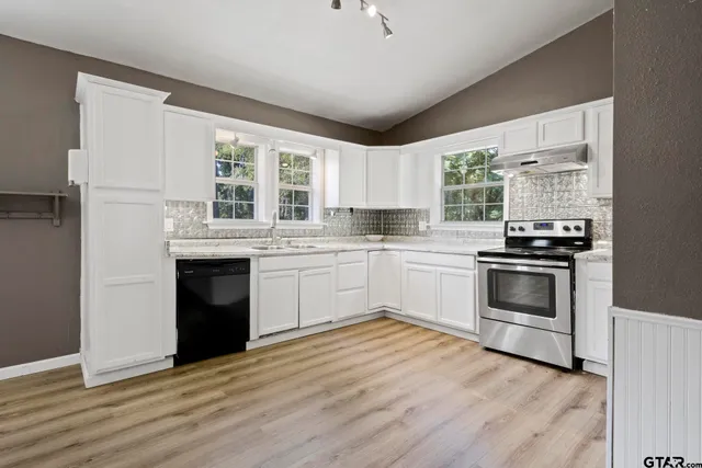 a kitchen with granite countertop a stove a sink and a microwave