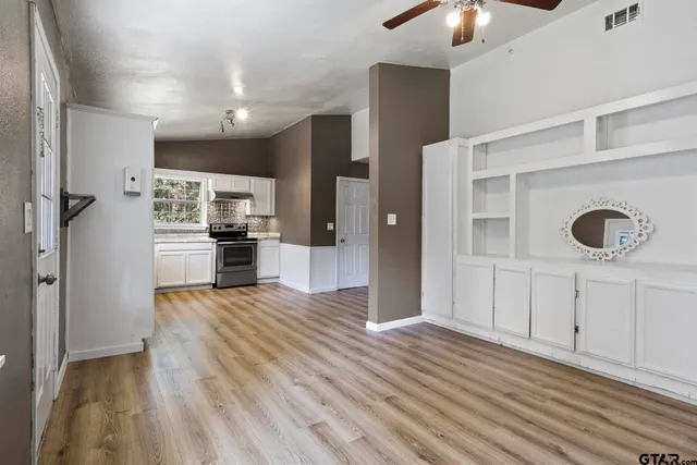 a view of a kitchen with wooden floor and electronic appliances