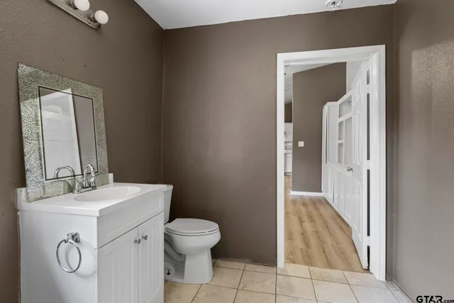 a bathroom with a sink mirror vanity and toilet