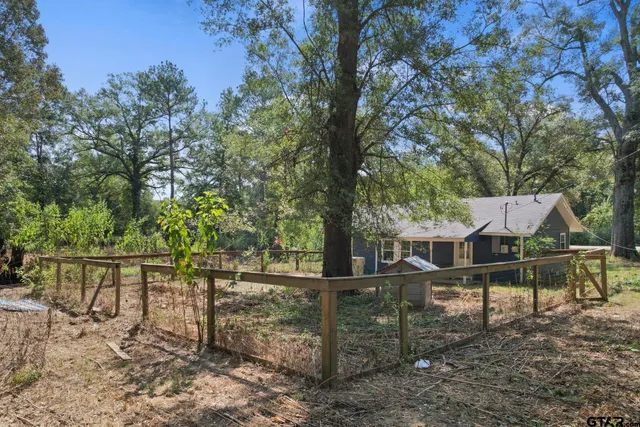 a view of house with wooden fence and a trees