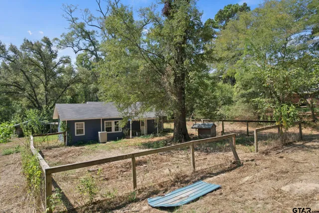 a view of house with a yard and sitting area