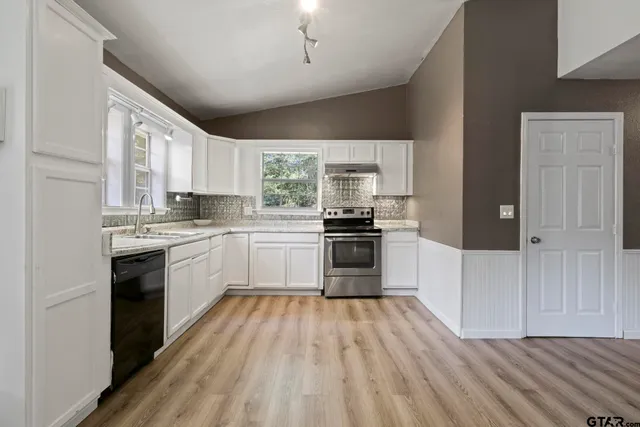 a kitchen with a refrigerator stove top oven and sink