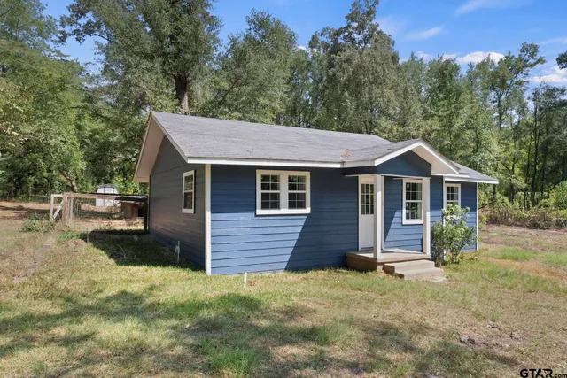 a front view of a house with yard and trees