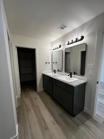 a bathroom with a double vanity sink and mirror
