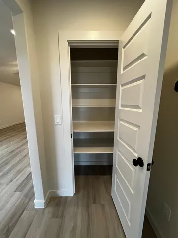 a view of walk in closet with wooden floor