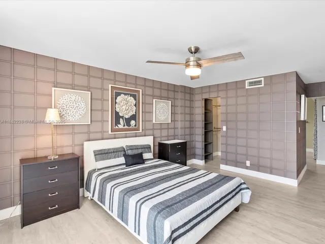 a bedroom with a large bed and a chandelier