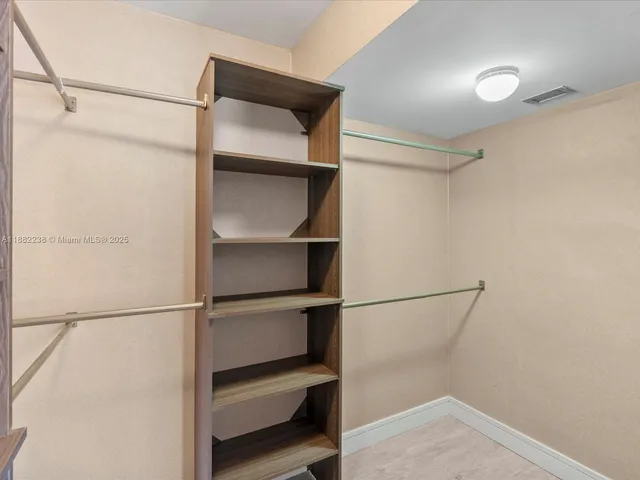 a view of walk in closet with empty racks