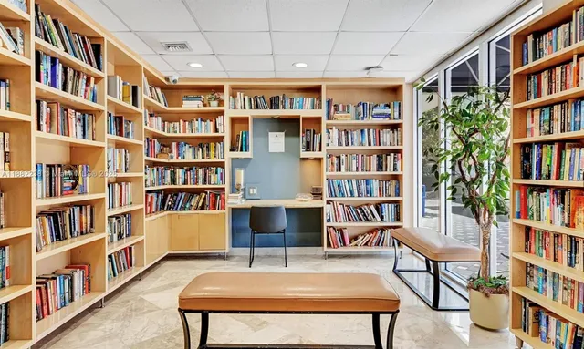 a view of a living room with furniture and a book shelf