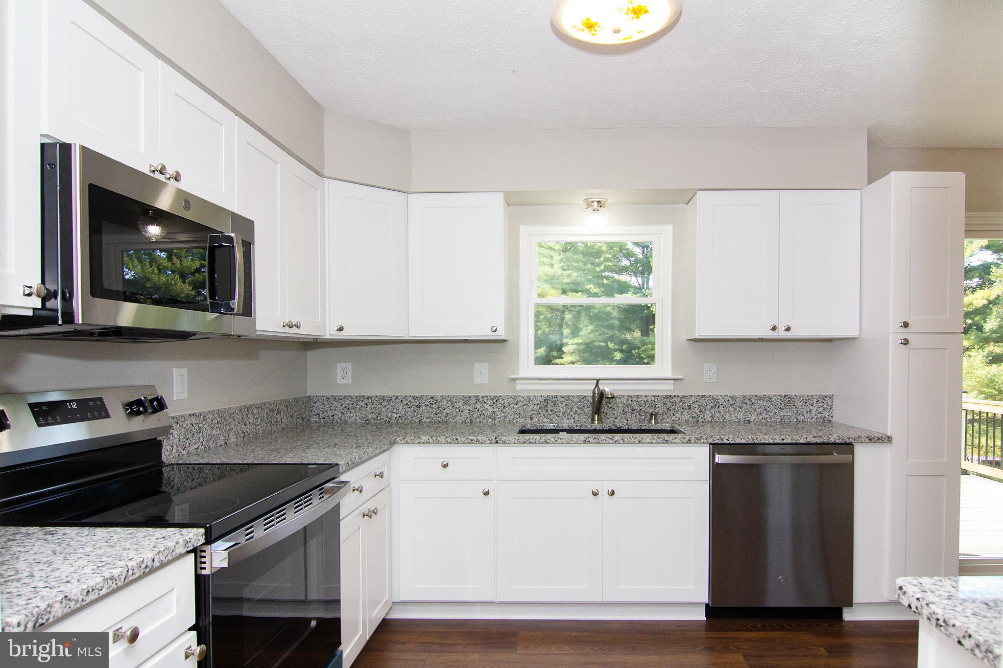 1526 Manchester Road Westminster, MD 21157 - Photo 10 of 41 a kitchen with granite countertop a stove a sink and a microwave