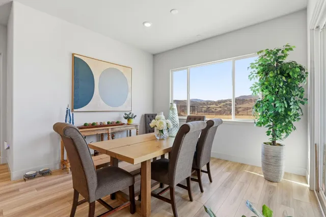 a dining room with furniture potted plants and wooden floor