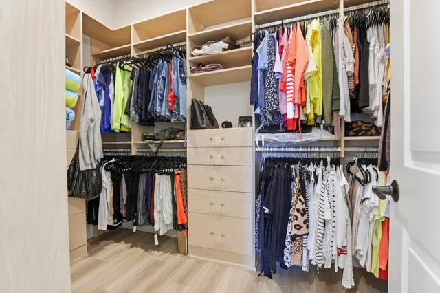 a view of walk in closet with clothes