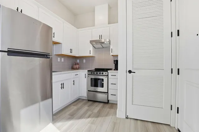 a kitchen with stainless steel appliances a refrigerator and cabinets